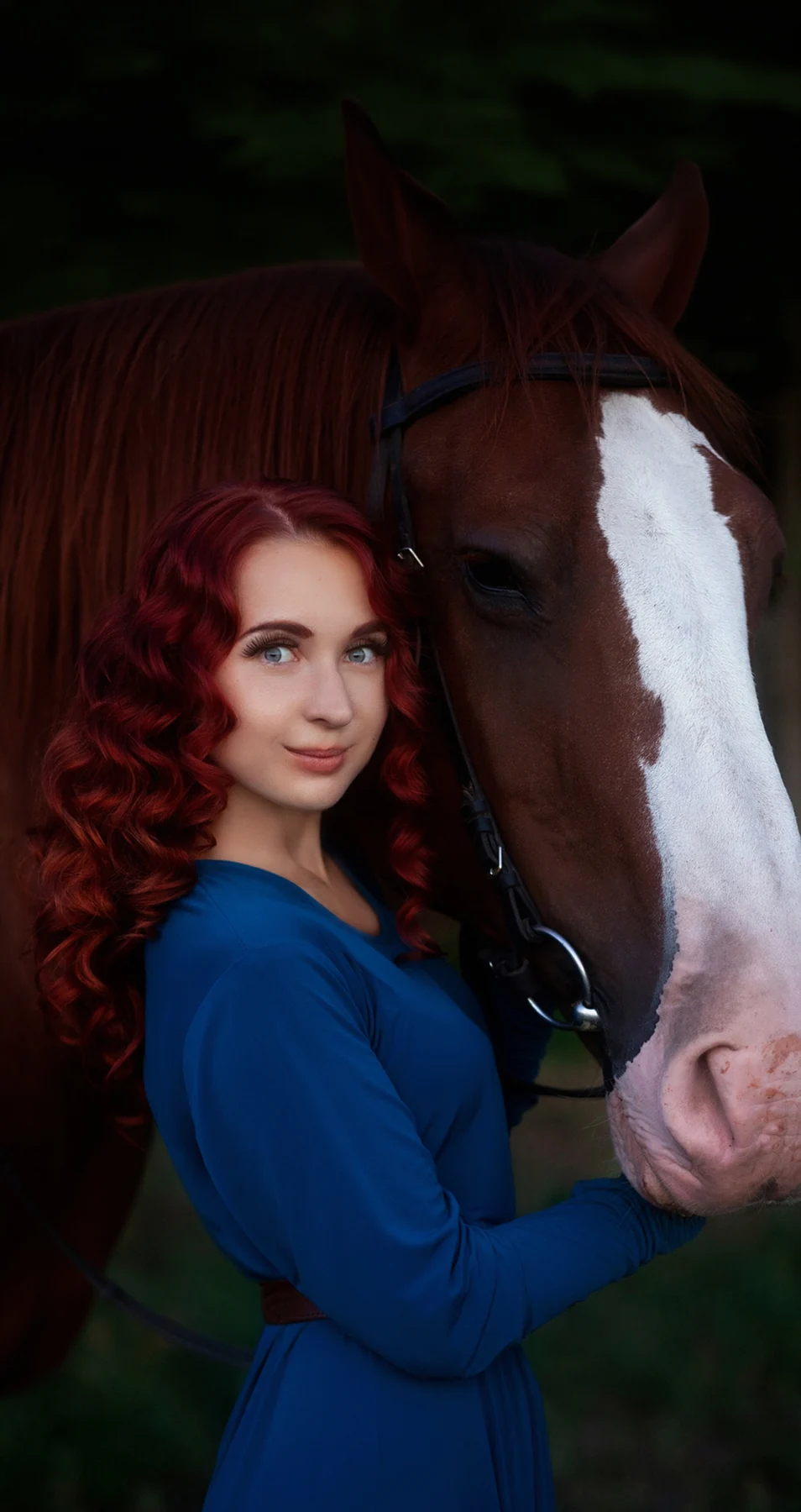 Featured portrait retouching of a woman in a blue dress standing beside a horse