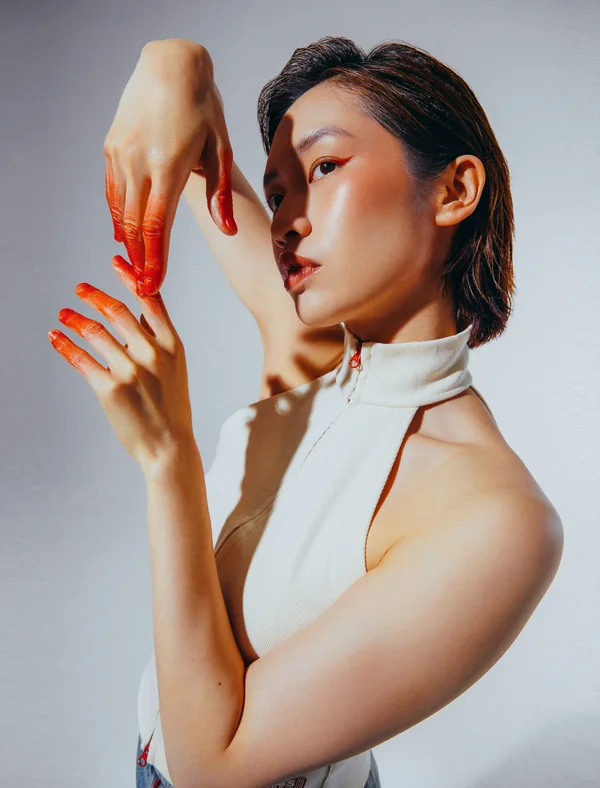 Editorial beauty portrait with hands framing the face after colour retouching